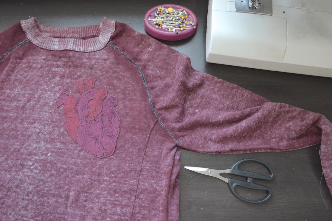 topstitching the anatomical heart onto the sweater