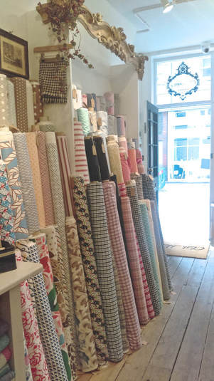 Rolls of fabric displayed in a shabby chic cloth house london store
